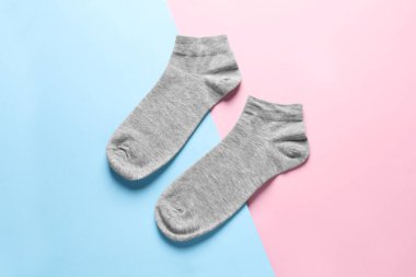 Pair of grey socks on colorful background, flat lay