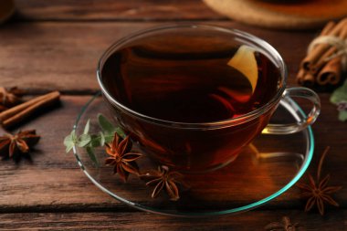 Aromatic tea with anise stars and mint on wooden table, closeup