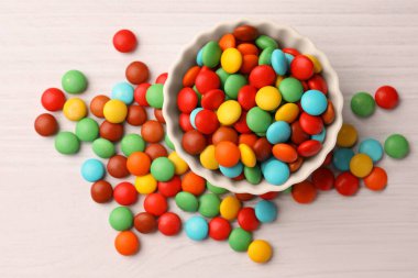 Tasty colorful candies on white wooden table, flat lay