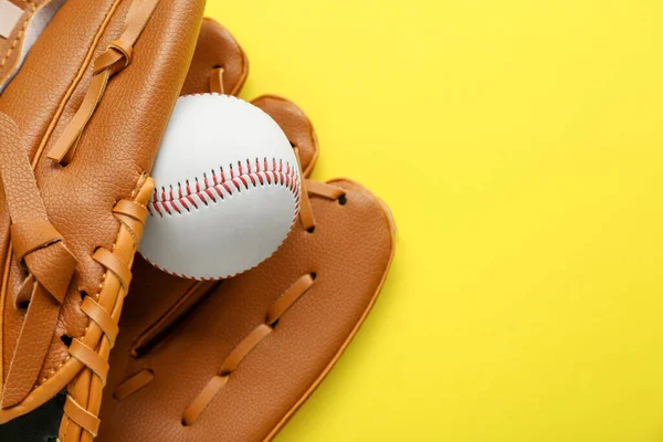 Catcher\'s mitt and baseball ball on yellow background, top view with space for text. Sports game