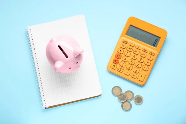 Piggy Bank Coins Notebook Calculator Light Blue Background Flat Lay — Zdjęcie stockowe