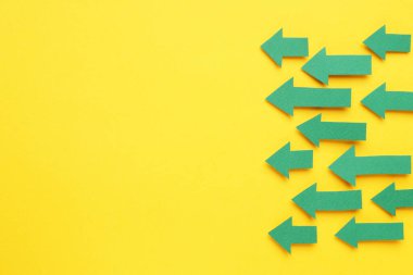 Sarı arka planda kağıt oklar, düz yatış. Metin için boşluk