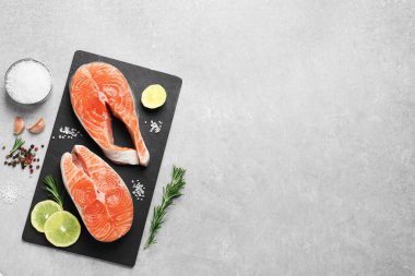Fresh salmon and ingredients for marinade on light grey table, flat lay. Space for text