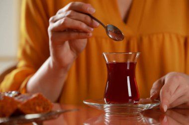 Woman with traditional Turkish tea at table, closeup