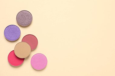 Different beautiful eye shadows on beige background, flat lay. Space for text