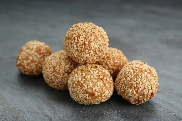 Many delicious sesame balls on grey table, closeup