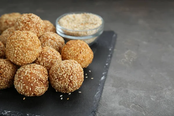Delicious sesame balls on grey table, closeup. Space for text