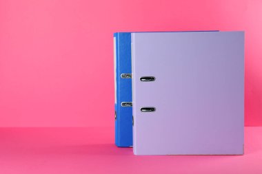 Office folders on pink background, space for text