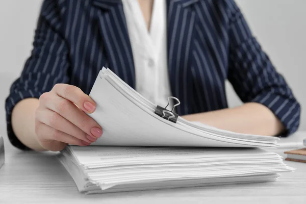 stock image Woman reading documents at white wooden table in office, closeup