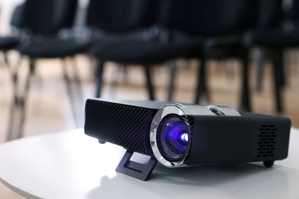 Modern video projector on table in conference room