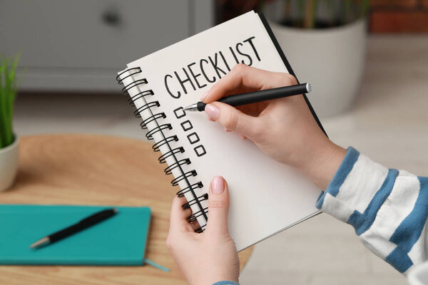 Woman filling Checklist with pen indoors, closeup