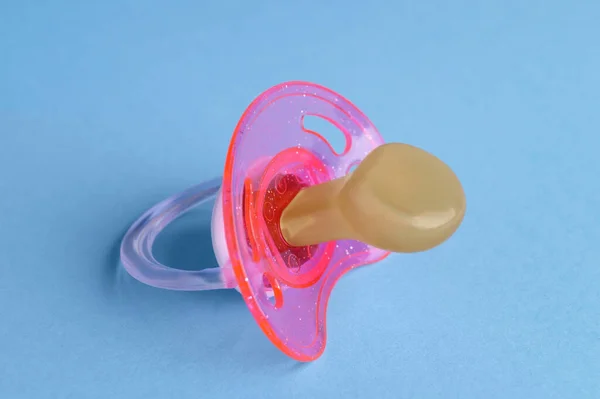 New baby pacifier on light blue background, closeup