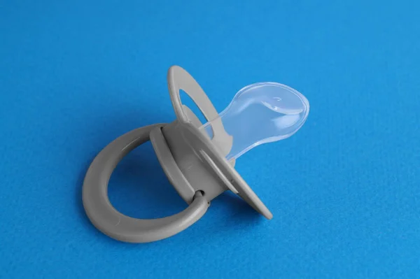 One new baby pacifier on blue background