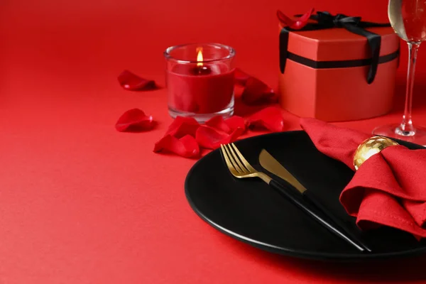 ギフトボックスとロマンチックなディナーのための赤いテーブルの上に燃えるろうそくと美しいテーブルの設定 テキストのスペース — ストック写真