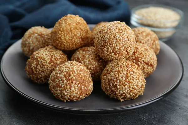 Many delicious sesame balls on grey table, closeup