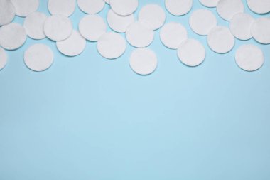 Açık mavi arka planda bir sürü pamuk pedi var. Metin için boşluk