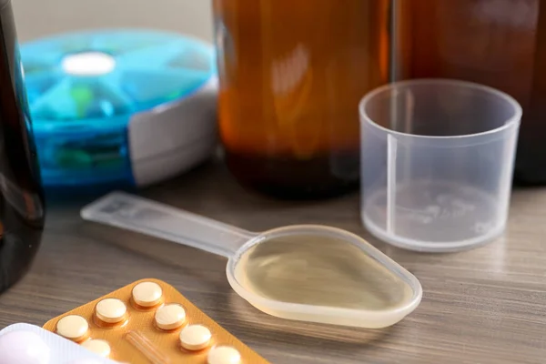 Dosing Spoon Syrup Measuring Cup Pills Wooden Table Closeup Cold — Foto de Stock
