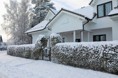 Winter landscape with beautiful house, trees and bushes in morning