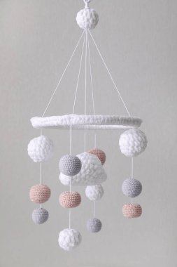 Bej duvarın yanında modern bebek karyolası var.