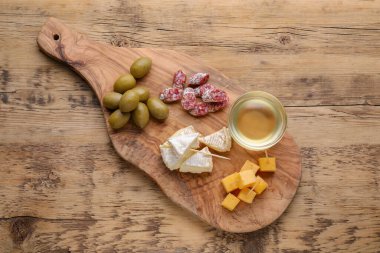 Toothpick appetizers. Pieces of sausage, cheese and honey on wooden table, top view