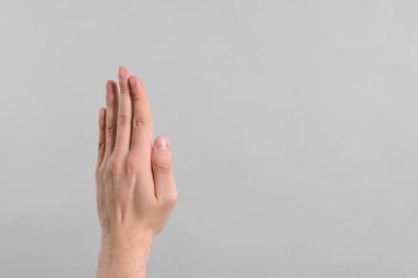 Man giving high five on grey background, closeup of hand. Space for text