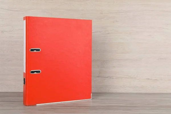 Orange office folder on white wooden table, space for text