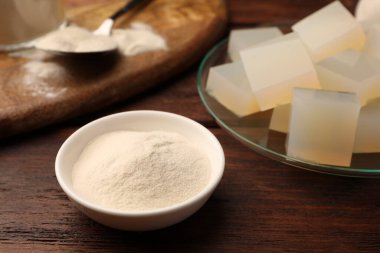 Agar-agar jelly cubes and powder on wooden table, closeup