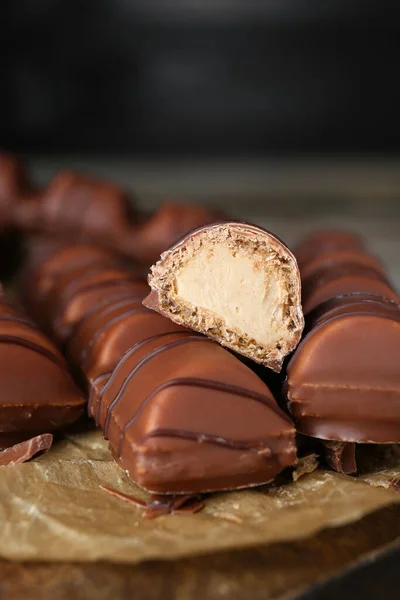 Tasty chocolate bars on wooden board, closeup