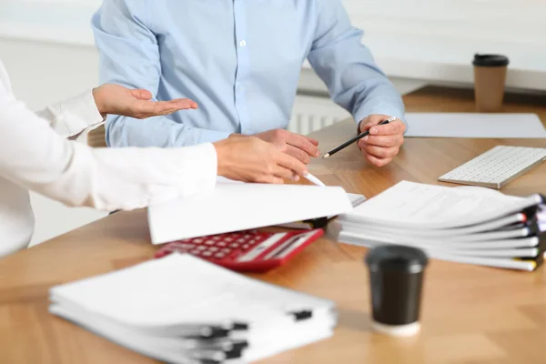 Businesspeople working with documents at table in office, closeup