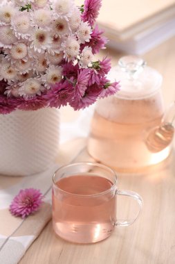 Taze bitkisel çay, kitaplar ve ahşap masada güzel bir buket.
