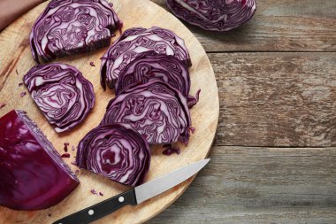 Tray with slices of fresh red cabbage on wooden table, flat lay. Space for text