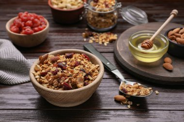 Tasty granola served with nuts and dry fruits on wooden table