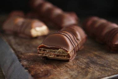 Tasty chocolate bars on wooden board, closeup