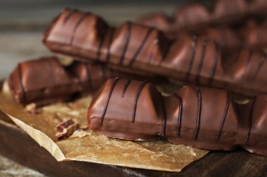 Tasty chocolate bars on wooden board, closeup