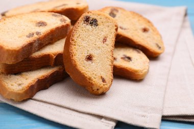Sweet hard chuck crackers with raisins on light blue wooden table, closeup
