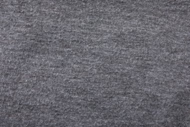 Grey cloth with lint as background, closeup. Before using of fabric shaver
