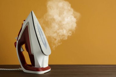 Buharlı modern demir ahşap masa üzerinde turuncu arkaplan, metin için boşluk