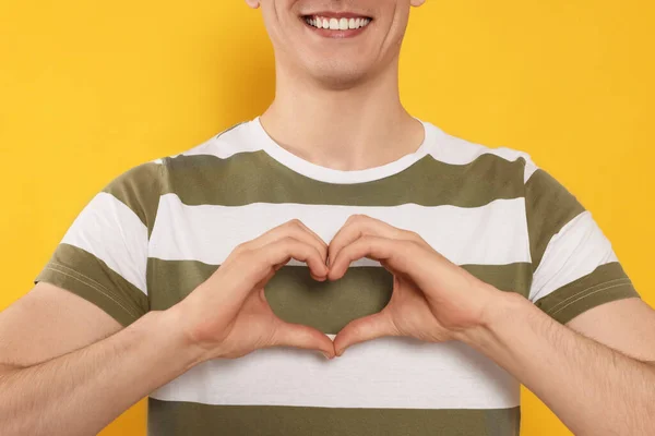 Happy Volunteer Making Heart His Hands Orange Background Closeup — Stockfoto