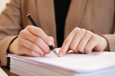 Ofiste evrakları imzalayan kadın, yakın plan.