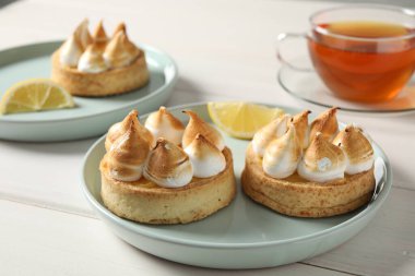 Beyaz ahşap masada lezzetli limonlu pastalar.