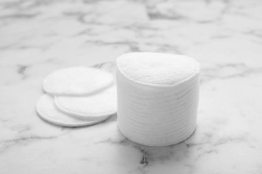 Stack of clean cotton pads on white marble table