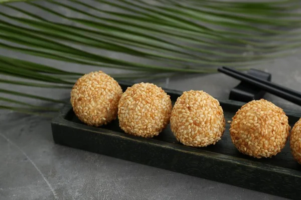 Delicious sesame balls and green leaf on grey table