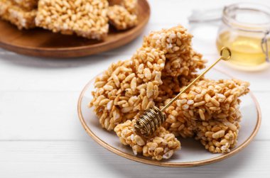 Puffed rice bars (kozinaki) on white wooden table, closeup