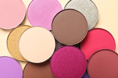 Different beautiful eye shadows on beige background, flat lay