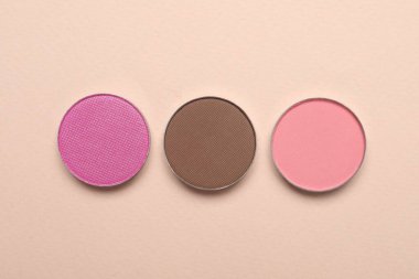 Beautiful eye shadow refill pans on beige background, flat lay