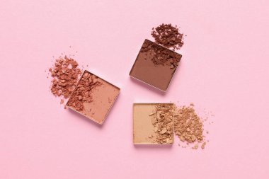 Crushed eye shadows on pink background, flat lay. Professional makeup product