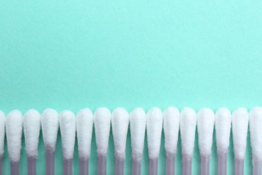 Turkuaz arka planda bir sürü pamuk tomurcuğu var. Metin için boşluk