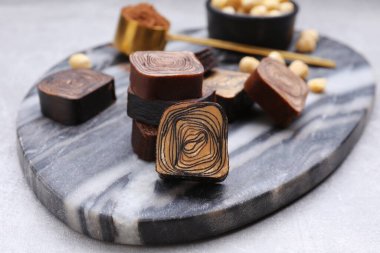Tasty chocolate candies on light grey table, closeup