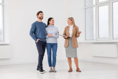 Emlakçı çiftlere yeni bir daire gösteriyor.