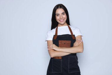 Portrait of happy hairdresser on light background